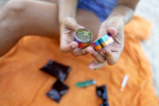 Woman grinding cannabis outdoors