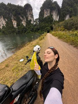 UGC female takes a selfie in scenic spot next to her motorcycle 