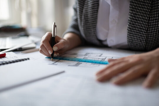 Cropped architect drawing blueprint on table