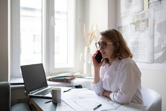 Friendly female architect making call to client