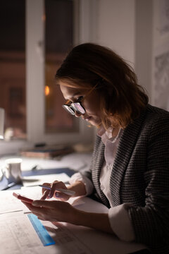Young architect using smartphone at night