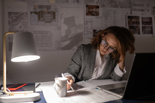 Exhausted businesswoman making notes on draft