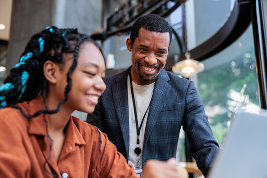 Smiling man and woman looking at laptop screen together.