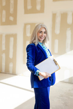 portrait of businesswoman holding documents smiling at camera