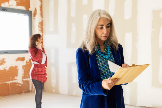 Realtor agent speaking on phone while client check documents