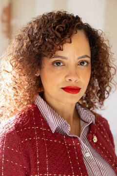Headshot of businesswoman in red suit looking at camera