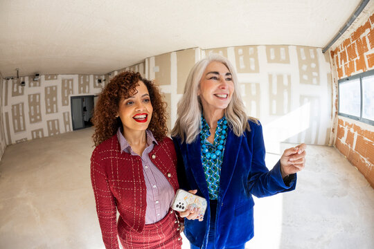 Interior designer team smiling in new client space for renovation. 