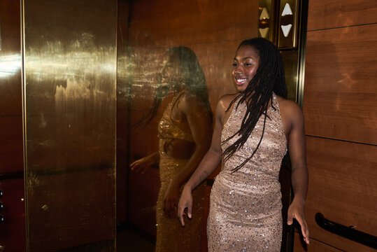 Girl in elevator with shiny dress