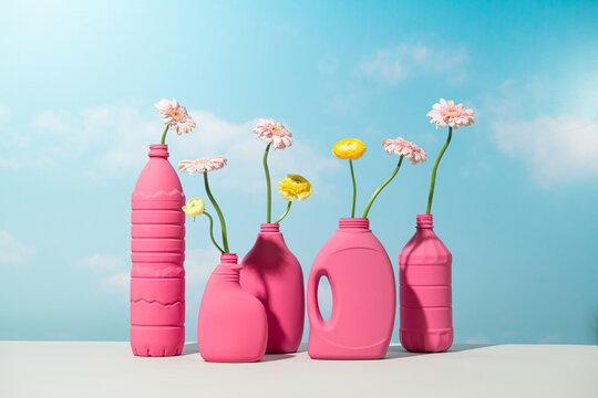 Pink plastic bottles repurposed as vases holding delicate flowers