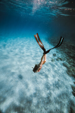 freediver descending in turquoise shallow waters