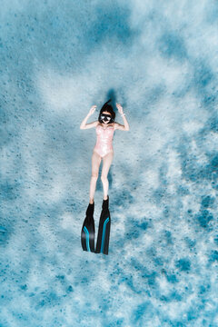 freediver floating above bright seabed