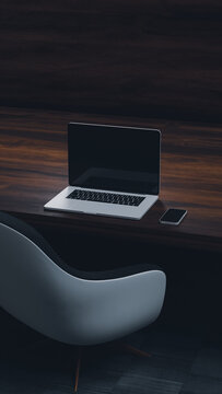 Modern desk setup with laptop and chair in indoor space