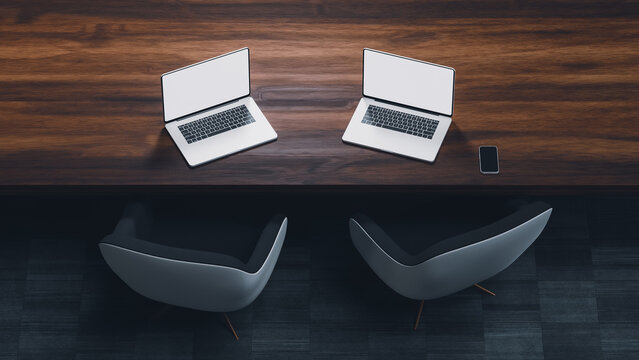 Modern desk with laptops and chairs in a workspace setting