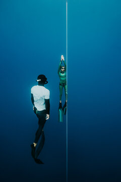 safety diver observing freediving athlete on training line