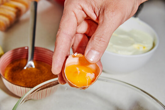 egg white dripping into a bowl during dessert preparation