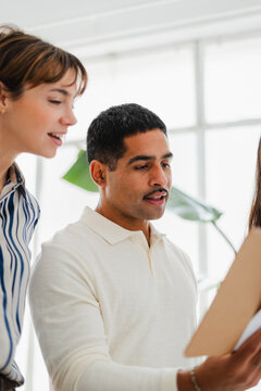 Man reviews paperwork with his colleagues