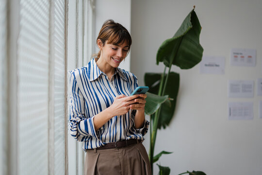 Beautiful elegant woman send texts via her phone
