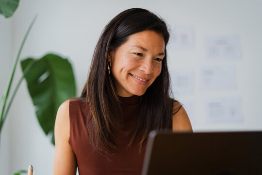 Smiling businesswoman looking at her laptop