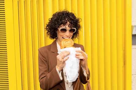 Woman eating pastry outdoors