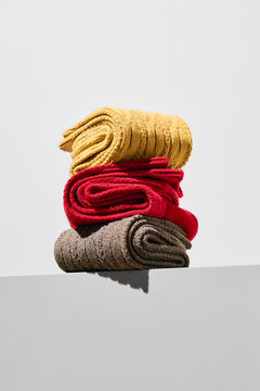 Colorful socks stacked on a shelf in bright light