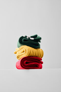 Colorful socks stacked on a light surface