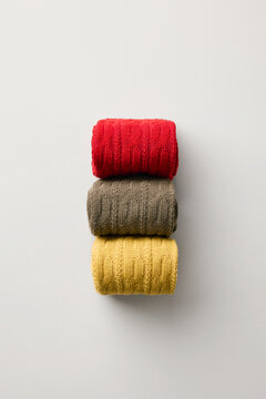 Socks stacked in soft colors on a plain surface