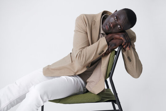 A man seated thoughtfully on chair