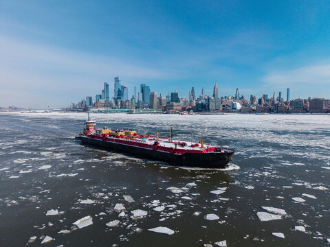 Red tanker ship on icy Hudson River
