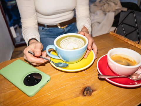 Person having matcha latte and espresso at cafe