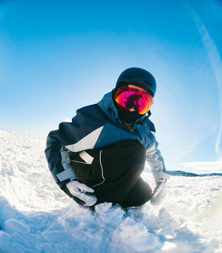Snowboarder Kneeling in Snow on Open Mountain Slope