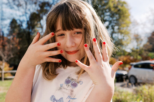 little girl proudly showing her painted nails