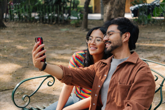 Close up of a happy couple taking a selfie on park swings