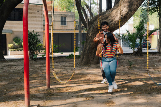 Friends playing on park swing