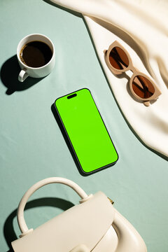 Flat lay of stylish accessories including a blankscreen smartphone