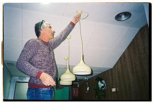 Man Repairs Hanging Lights