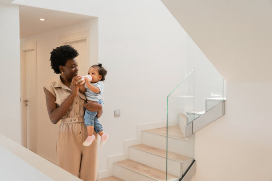 Mother feeding baby on a modern staircase