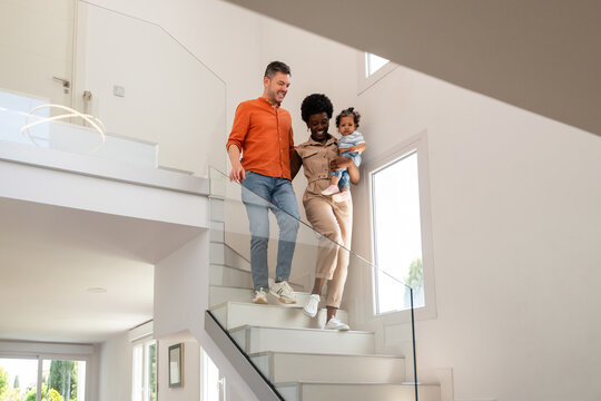 Family walking down the stairs in a bright modern home