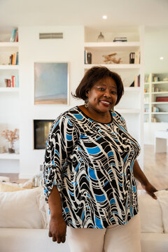 Woman smiling in modern living room with decor shelves