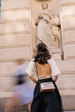 Stylish City Visitor Before Classical Statue