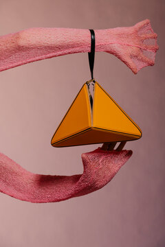 Orange Triangle Bag Suspended By Pink Ribbon