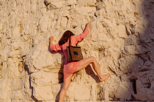 Climber Climbing Cliff At Sunset In Warm Light