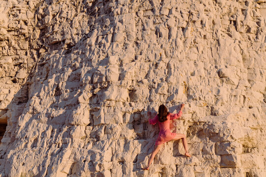 Climber On White Cliff In Pink Dress