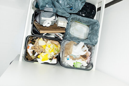 Recycling & sorting waste cardboard, plastic and bio waste in kitchen