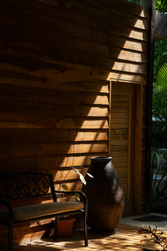 Rustic wooden terrace with a bench and artisanal clay vase