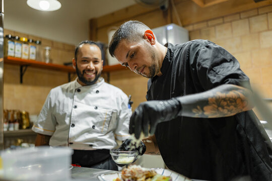 Chef colleagues preparing a dish in a professional kitchen