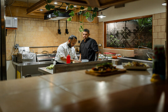 Chefs preparing food in a busy restaurant kitchen
