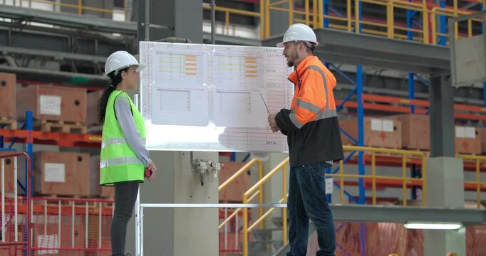 Rail engineers engaged in a planning and review session, focusing on a board displaying schedules, maintenance plans, and performance data of the rail systems. Ensuring efficient rail operations.