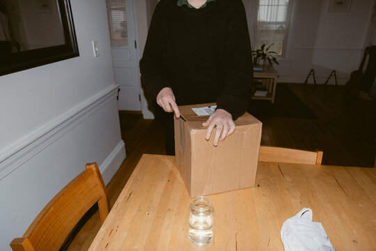 anonymous hands opening a package 
