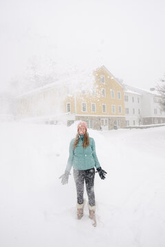 happy young woman throwing  snow in New England 