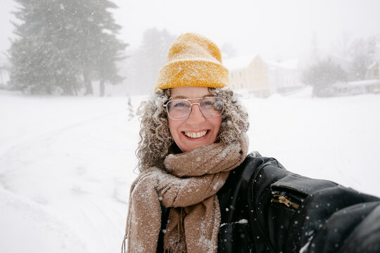 UGC selfie of happy middle aged woman  in snowstorm 